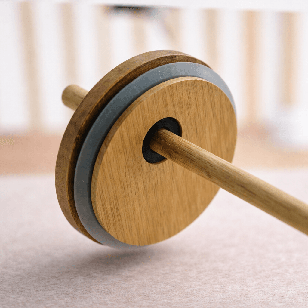 A close up of a wooden tumbler lid with a grey silicone seal, featuring a bamboo straw inserted through a central black grommet
